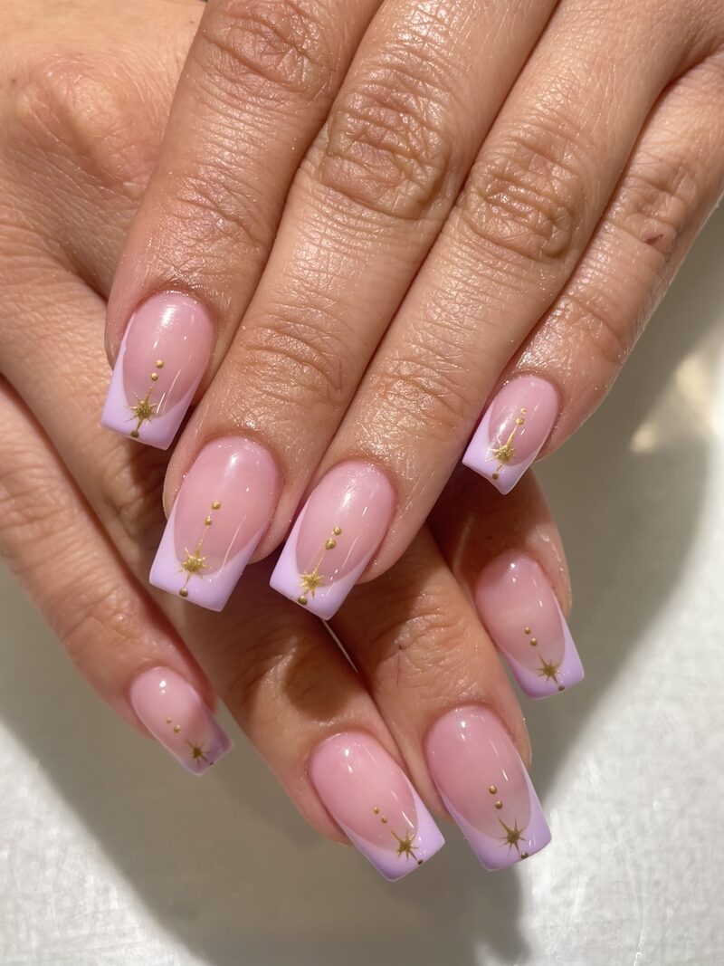 Sheer pink french tips with gold celestial star accents