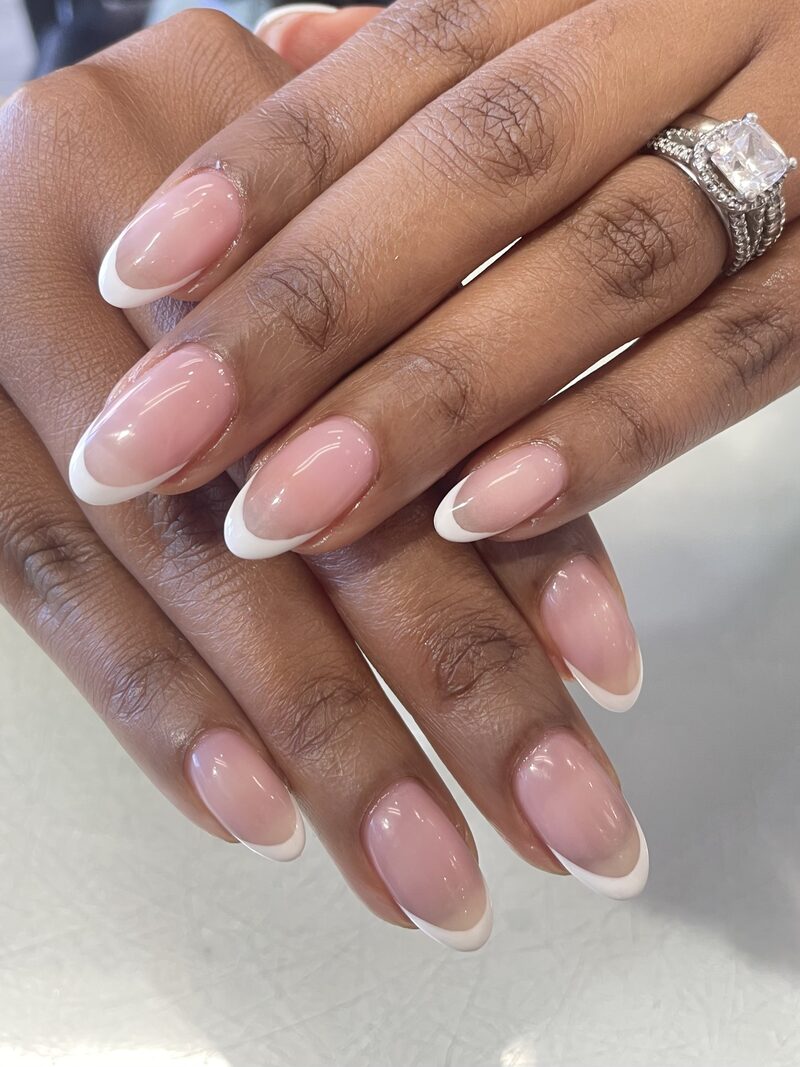 Nude pink almond nails with classic white french tips