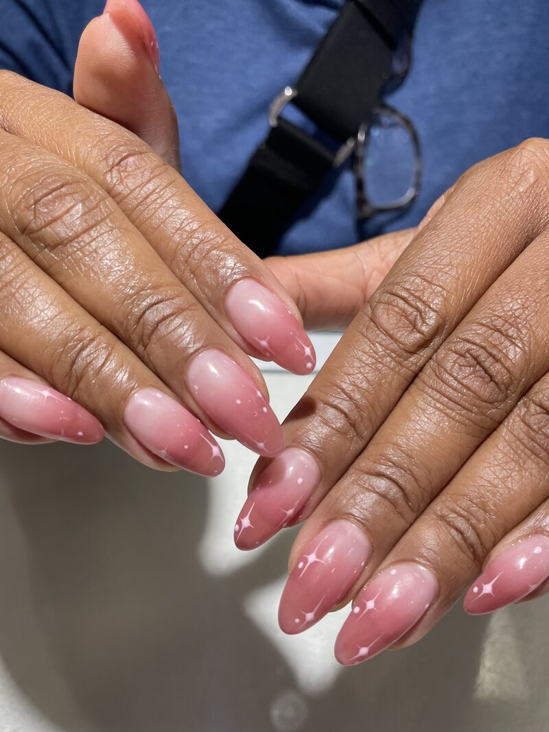 Sheer pink jelly almond nails with delicate white dot accents