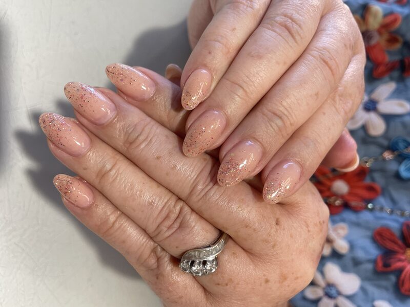 Nude shimmer almond nails with subtle glitter finish